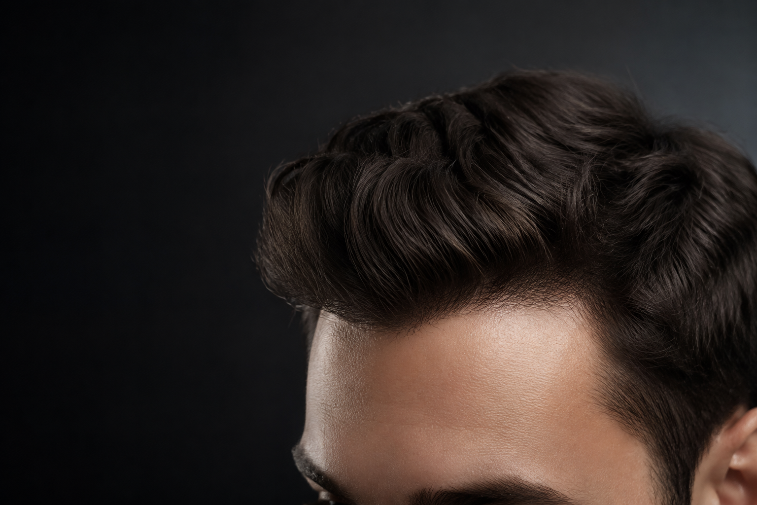 Close-up of a natural-looking men's hairline and styled dark hair
